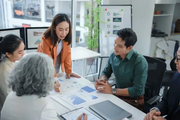 About 9 Marketing team analyzing statistical charts during briefing meeting